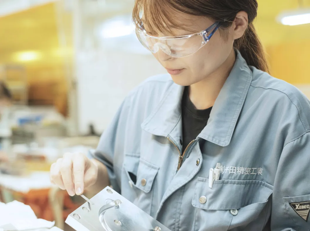 女性社員が金属加工をしている様子の画像